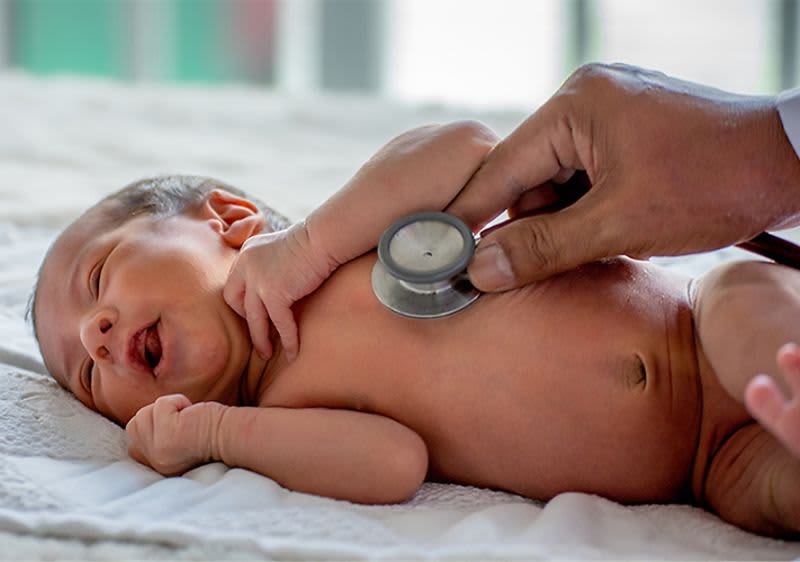 Baby wird mit einem Stethoskop abgehört