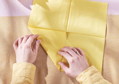 Falten der Serviettenecken zum Mittelpunkt