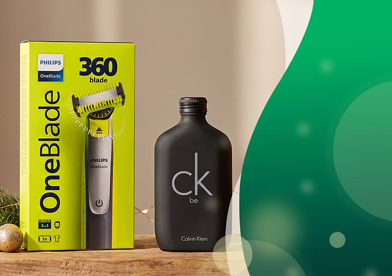 Gelbe Verpackung eines Philips OneBlade Rasierers mit Aufschrift „OneBlade“ und „360 blade“ neben einer schwarzen flachen Parfumflasche mit weißem Schriftzug „ck be“ von Calvin Klein. Bild mithilfe von KI erstellt