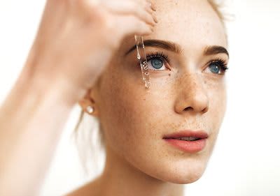 Hand hält Pipette mit Flüssigkeit