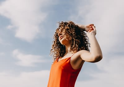 Frau mit lockigem Haar im Wind