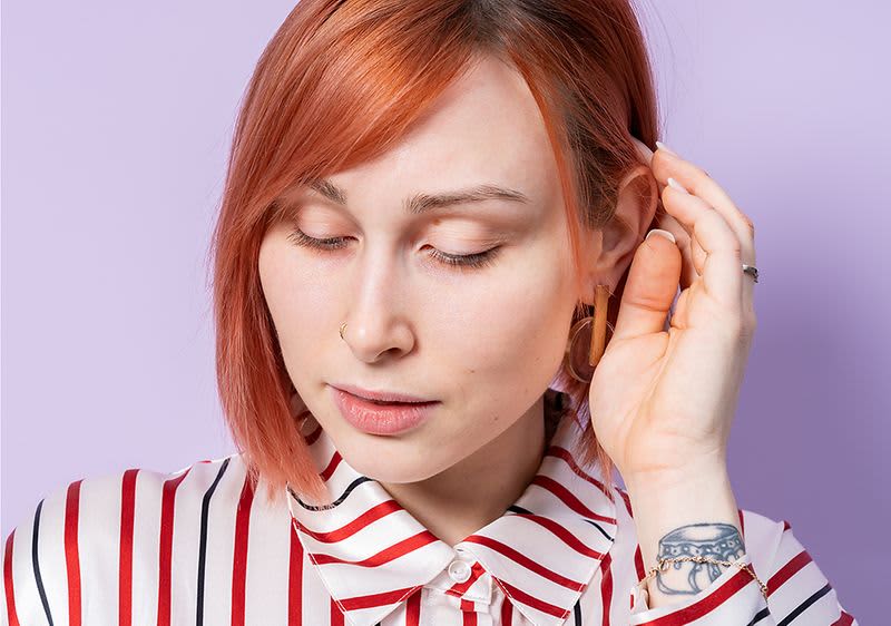 Frau mit rotbraunem Haar und gestreiftem Hemd