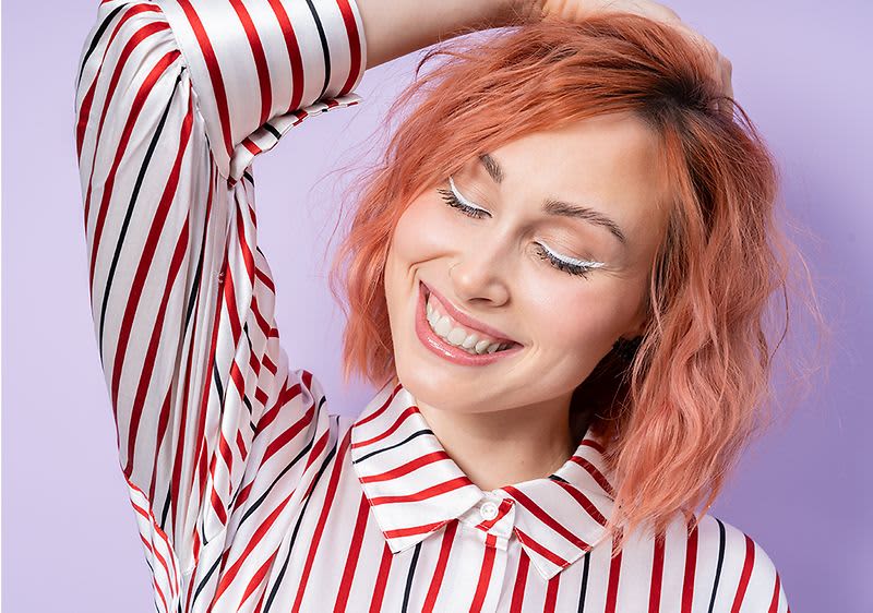 Frau mit gewellten und gefärbten roten Haaren