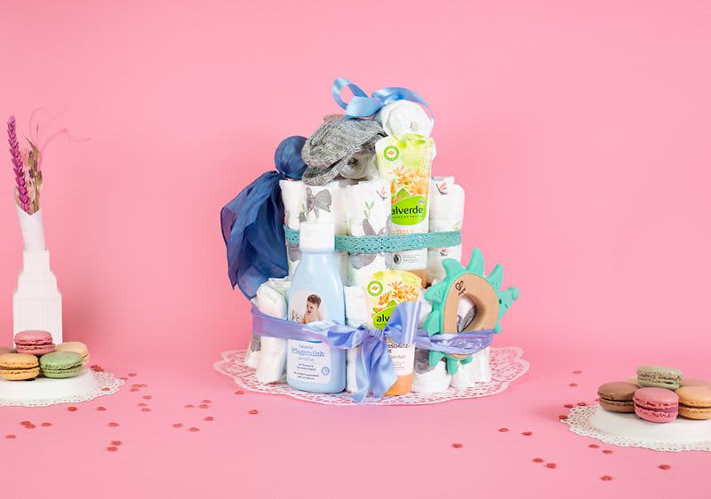 Geschmückter Tisch mit Muffins, Windeltorte und Getränken für die Babyparty