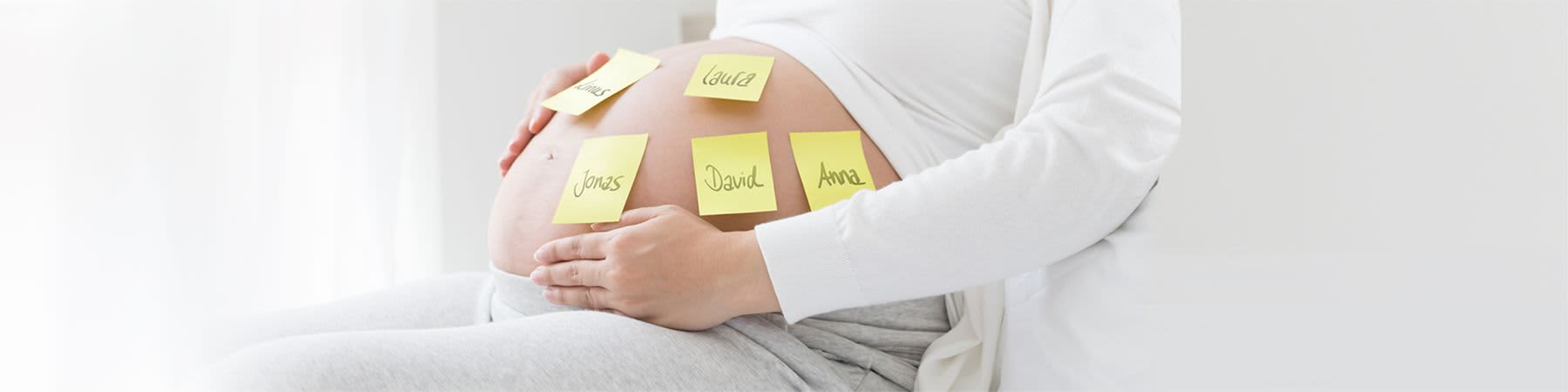 Babybauch mit verschiedenen Namen auf Post-Its