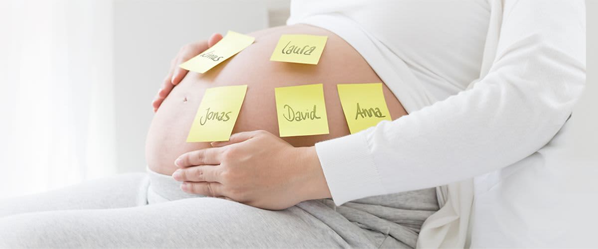 Babybauch mit verschiedenen Namen auf Post-Its