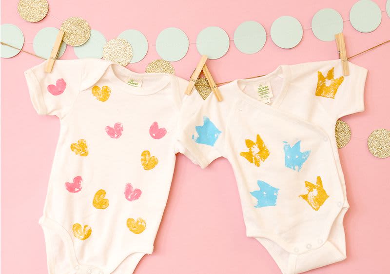 Zwei bedruckte Babybodys an einer Girlande befestigt
