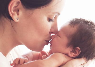 Mutter küsst Baby auf die Nase