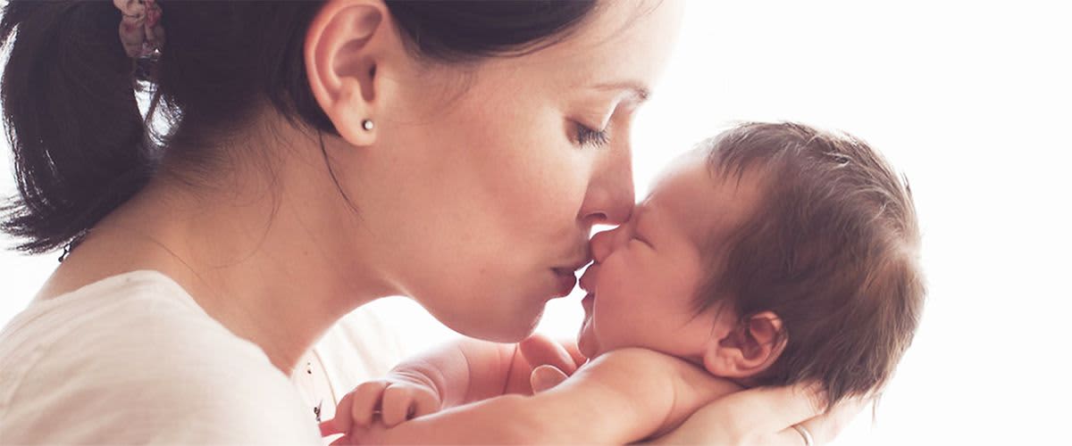 Mutter küsst Baby auf die Nase