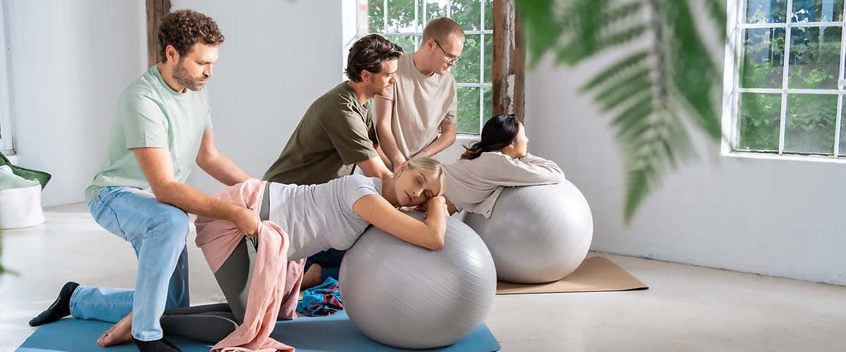 Menschen machen Übungen mit Gymnastikbällen