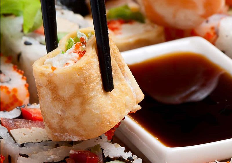 Frisches Sushi mit Stäbchen gehalten