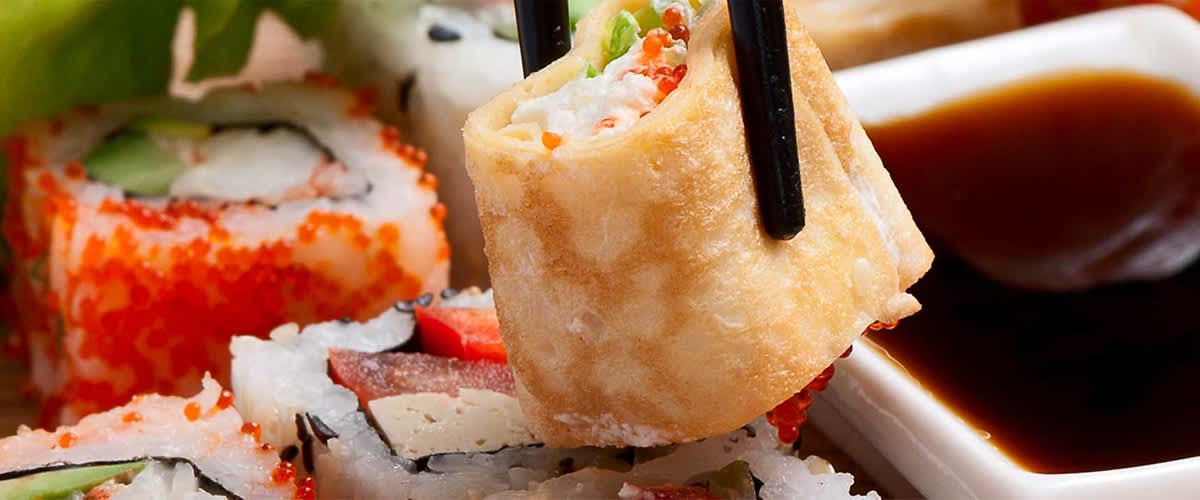 Frisches Sushi mit Stäbchen gehalten