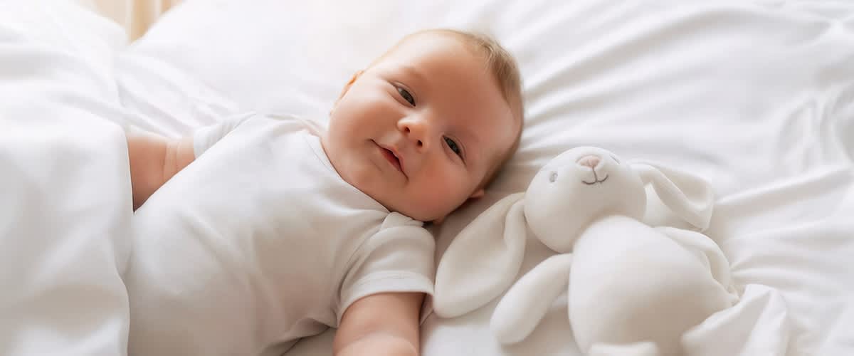 Baby im zweiten Monat mit Stofftier.. Bild mithilfe von KI erstellt