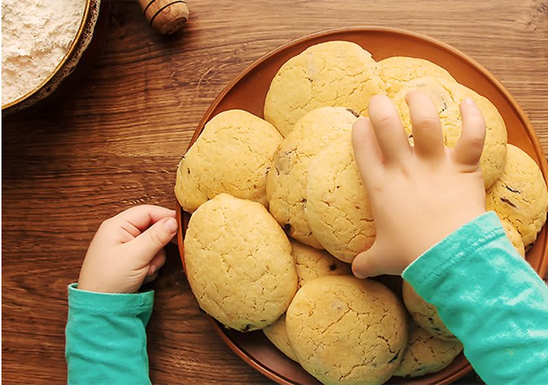 Kind greift nach Keksen