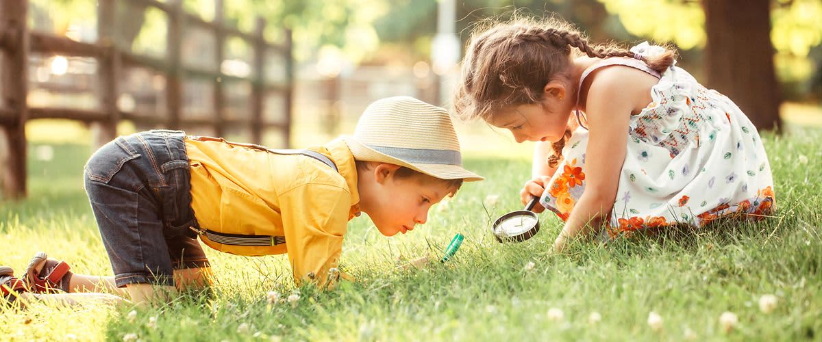 Kinder mit Lupe im Gras