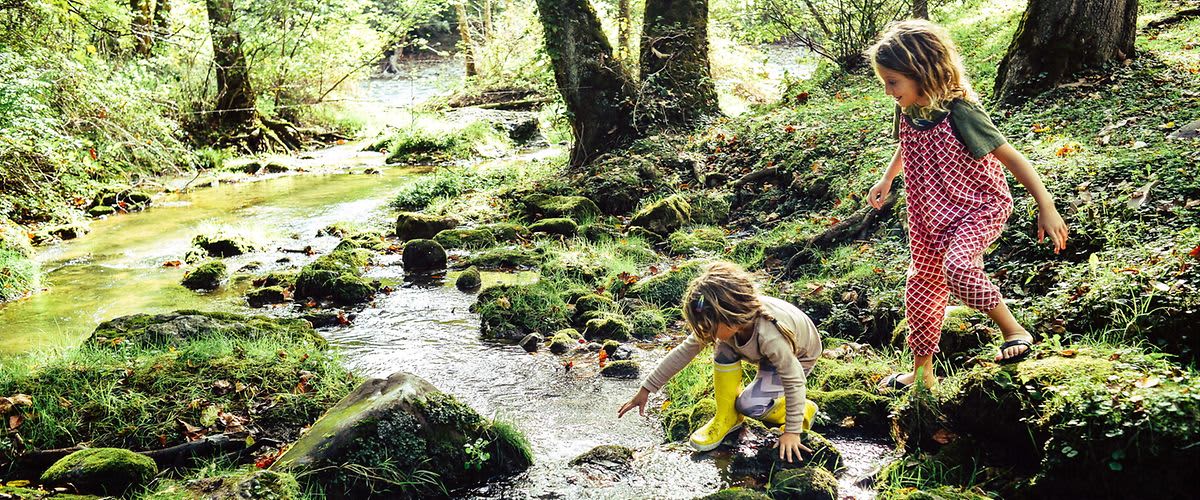 Kinder spielen am Bach