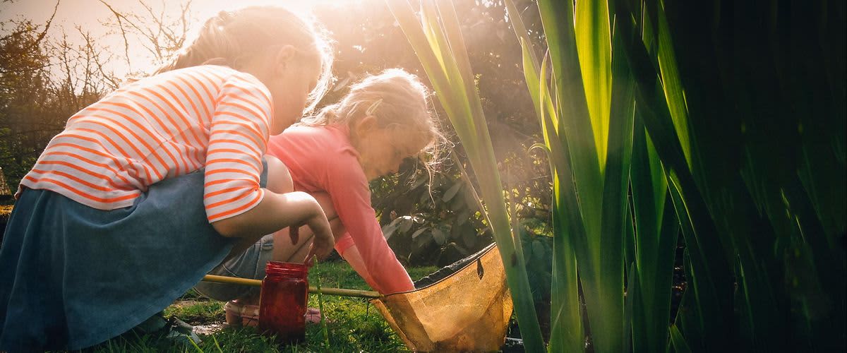 Kinder spielen am Teich