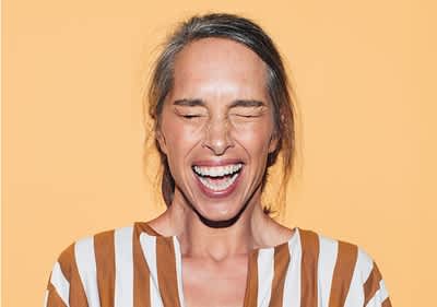 Frau mit gestreiftem Hemd vor gelbem Hintergrund