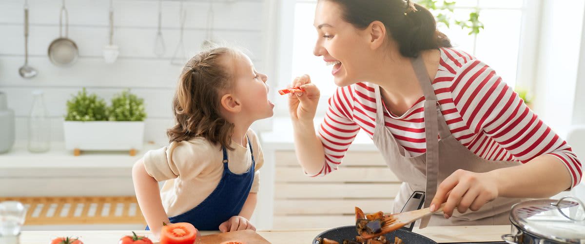 Mutter lässt Kinder Gekochtes probieren