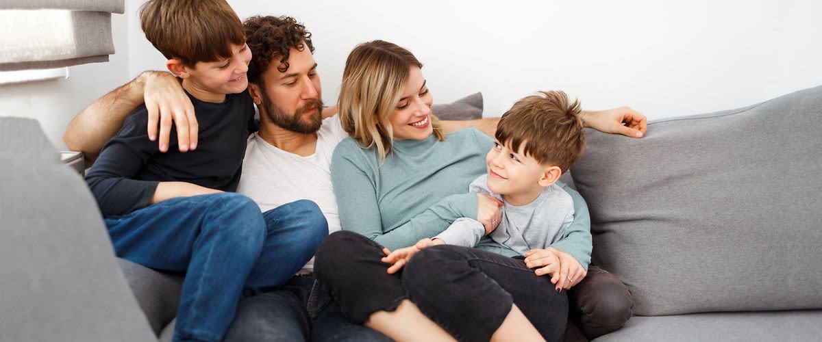 Familie sitzt auf Sofa