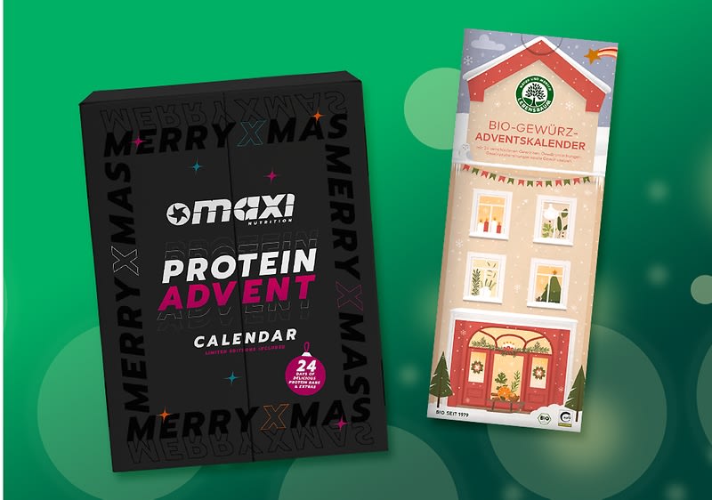 Zwei Adventskalender vor grünem Hintergrund: links eine schwarze rechteckige Packung mit weißer Aufschrift „maxi PROTEIN ADVENT CALENDAR“ und kleineren Texten, rechts ein helles, längliches Kalenderpaket mit Illustration eines Hauses und der Aufschrift „BIO-GEWÜRZ-ADVENTSKALENDER“. Bild mithilfe von KI erstellt