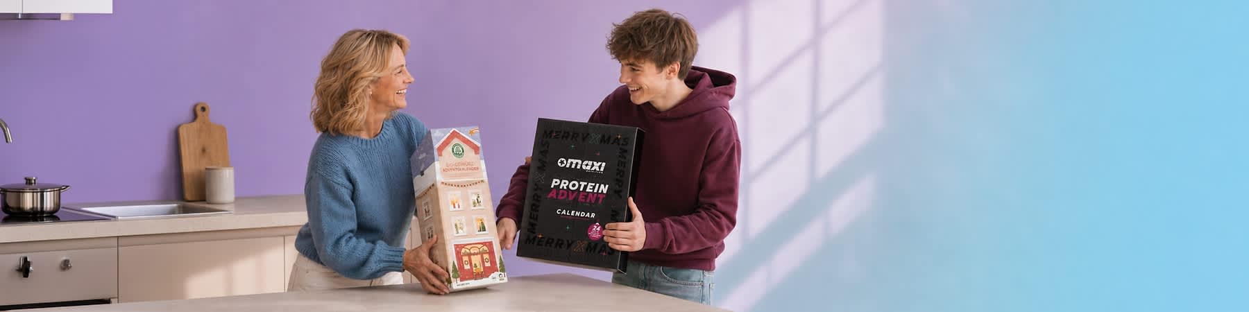Eine Frau und ein junger Mann sitzen auf einem Sofa und lächeln sich an; die Frau hält einen sechseckigen Bio-Gewürz-Adventskalender in Hausform, der junge Mann hält einen schwarzen Maxi Protein Advent Calendar-Kalender mit pinker Schrift. Bild mithilfe von KI erstellt