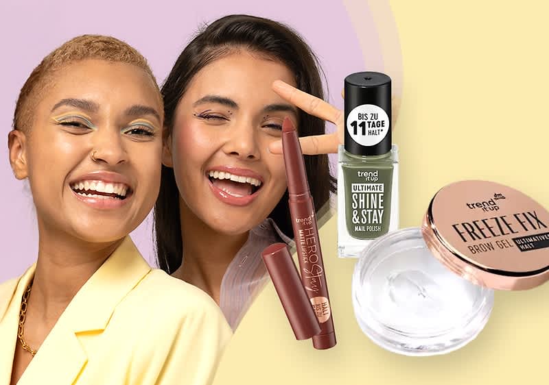 Zwei Kosmetikprodukte, ein grüner Nagellack mit der Aufschrift „trend IT UP SHINE & STAY“ und ein transparentes Augenbrauengel mit der Aufschrift „trend IT UP FREEZE FIX“, daneben ein brauner Lippenstift mit der Aufschrift „trend IT UP“