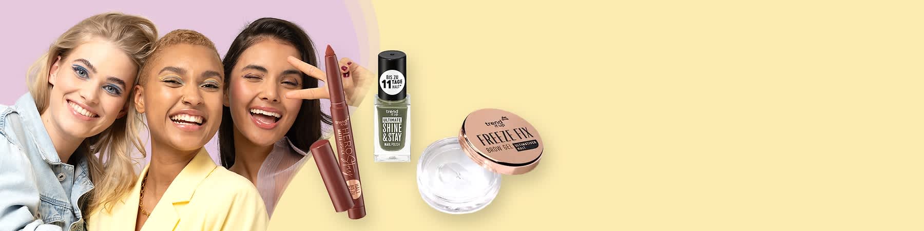 Zwei Kosmetikprodukte, ein grüner Nagellack mit der Aufschrift „trend IT UP SHINE & STAY“ und ein transparentes Augenbrauengel mit der Aufschrift „trend IT UP FREEZE FIX“, daneben ein brauner Lippenstift mit der Aufschrift „trend IT UP“