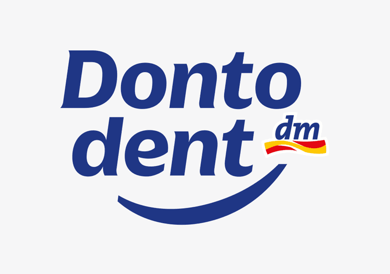 Logo der Zahnpflegemarke Dontodent in dunkelblauer Schrift mit einem dunkelblauen Lächel-Bogen darunter und kleinem roten-gelben dm-Logo am rechten oberen Bogen