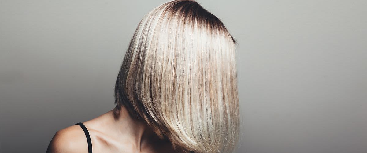 Frau mit glattem, blondem Bob-Haarschnitt