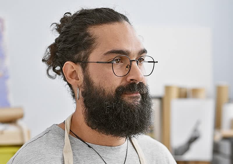 Muškarac s bradom koji gleda u daljinu