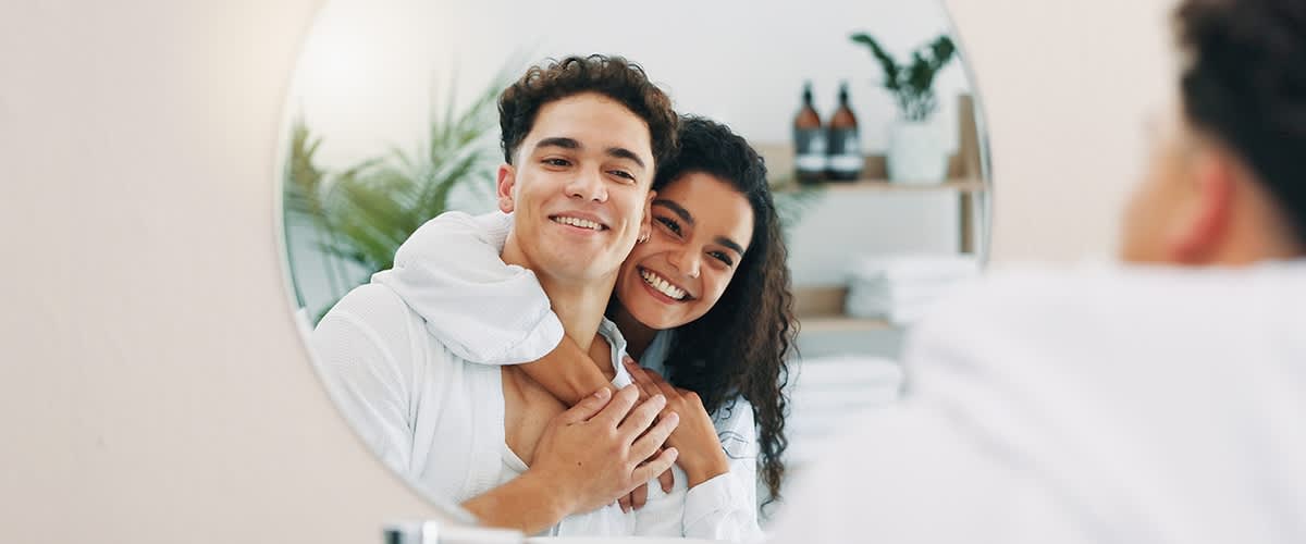 Muškarac i djevojka zagrljeni gledaju se u ogledalo