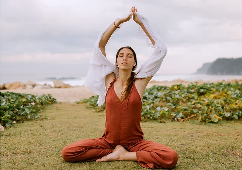 Žena koja meditira na plaži