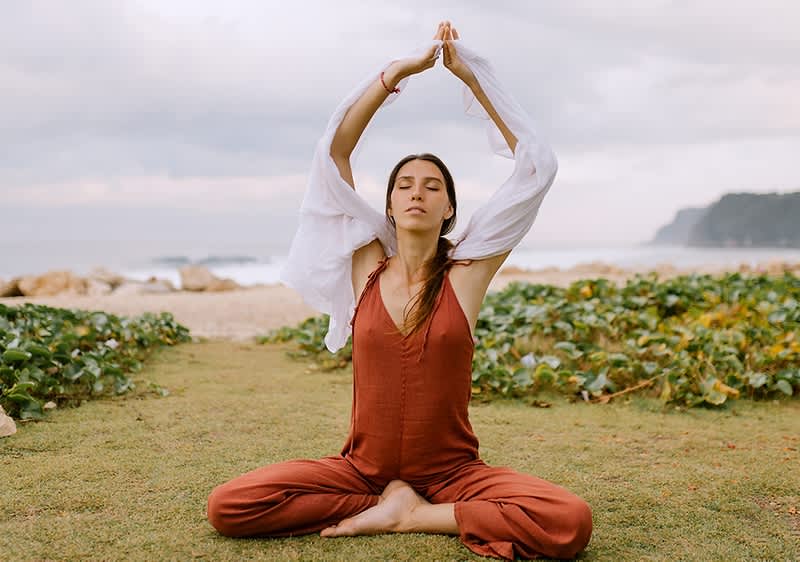 Žena koja meditira na plaži