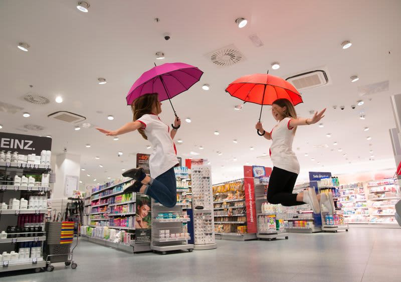 dm prodavačice skaču od sreće s kišobranima u dm prodavaonici