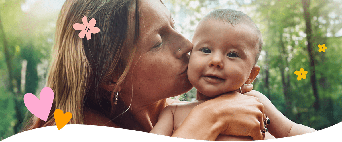 Mama ljubi bebu okružena cvijećem i srcima
