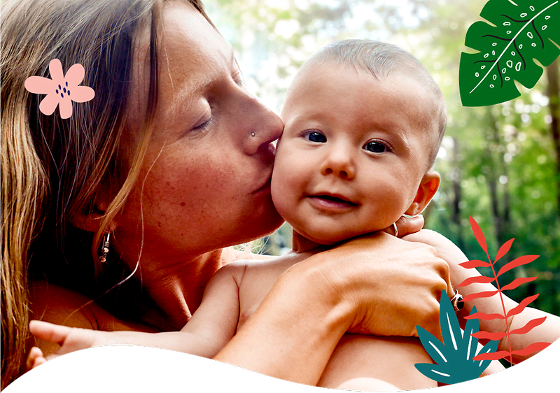 Mama ljubi bebu okružena cvijećem i srcima