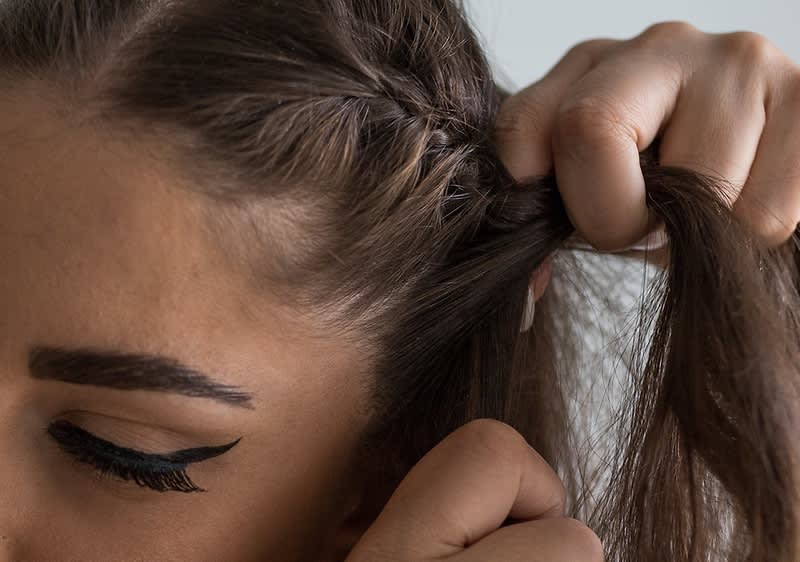 djevojka plete pletenicu s kosom