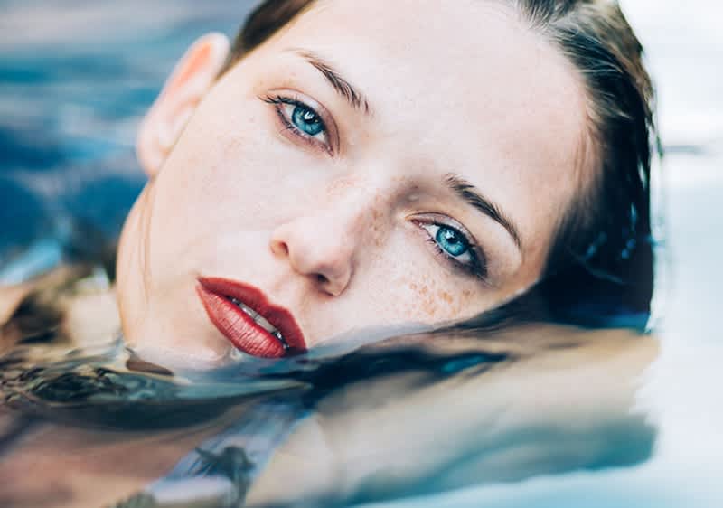 Našminkana žena pliva u vodi
