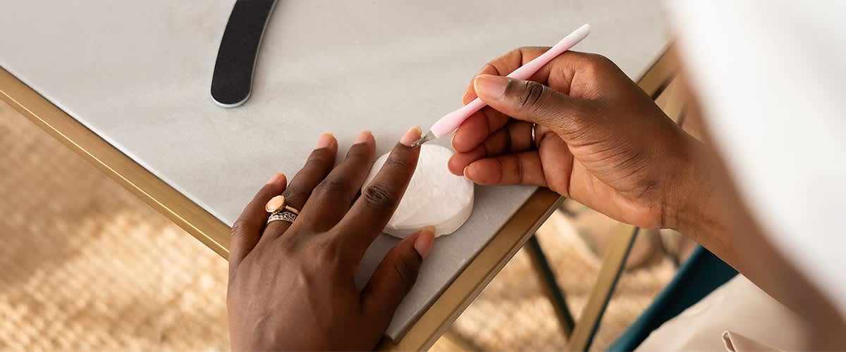 Žena uklanja kožicu oko noktiju na rukama