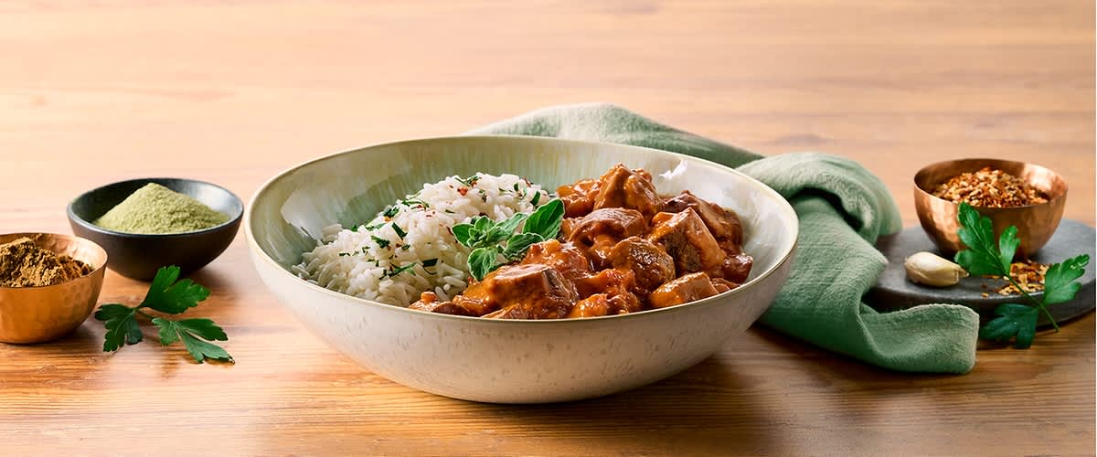 Tikka Masala s rižom u zdjeli na drvenom stolu