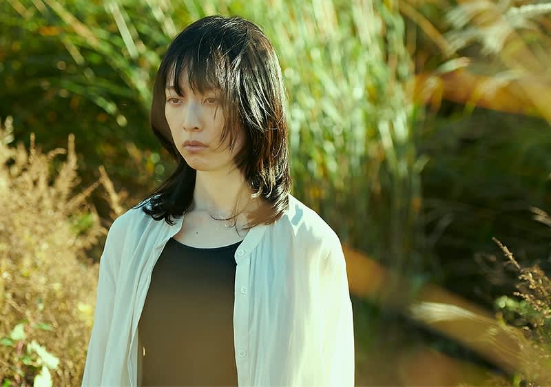 Žena u bijeloj košulji u zelenilu