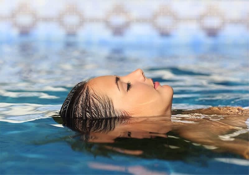 Djevojka pliva leđno u vodi