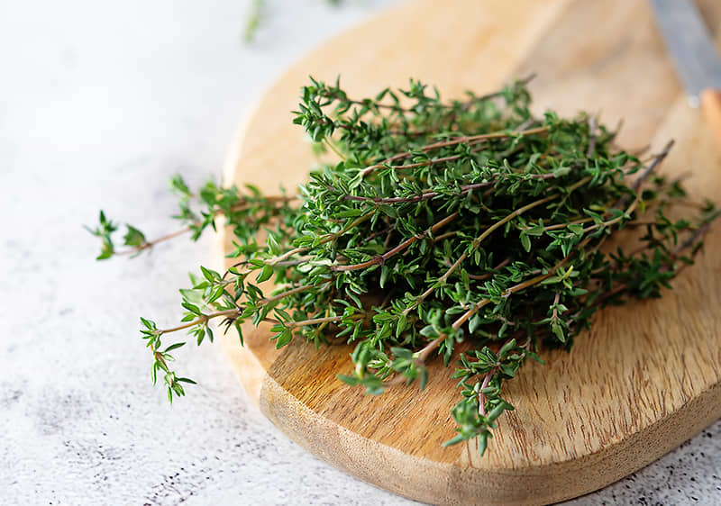 Timijan na drvenoj kuhinjskoj dasci