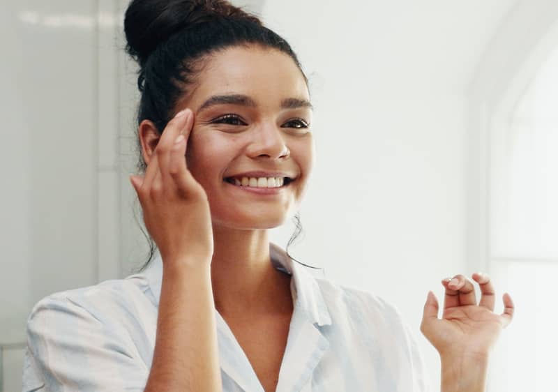 Djevojka se gleda u ogledalo nasmiješeno