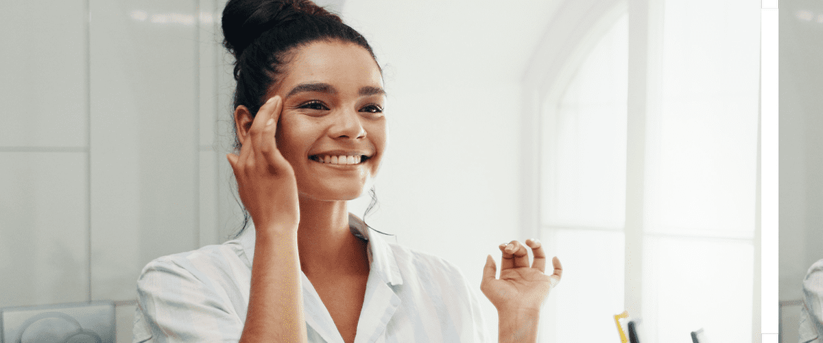 Djevojka se gleda u ogledalo nasmiješeno