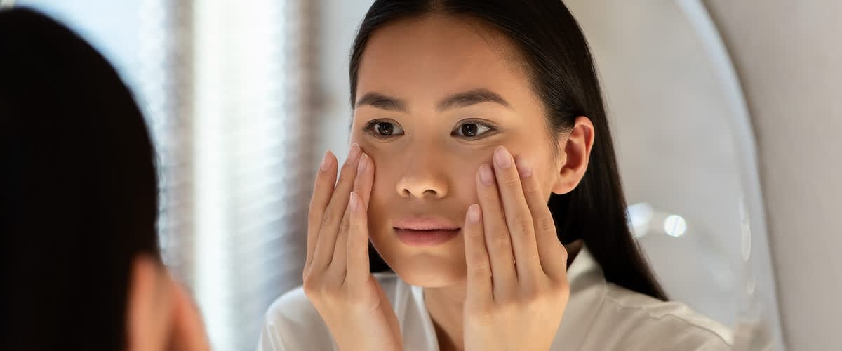 djevojka promatra svoje lice u ogledalu