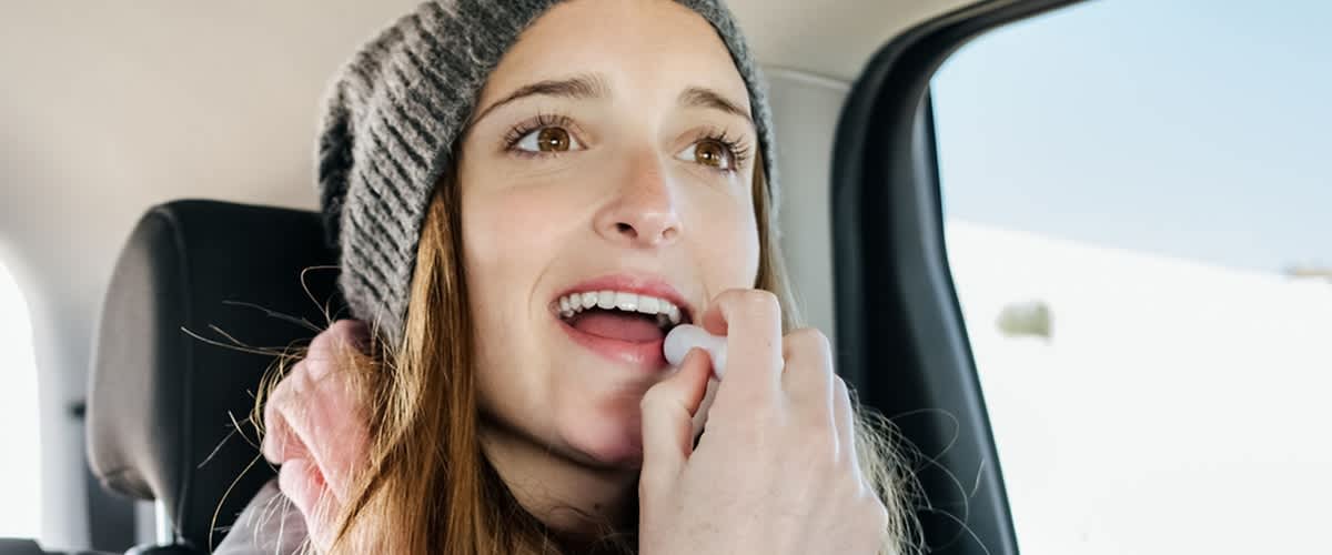 Djevojka sa zimskom kapom maže usne