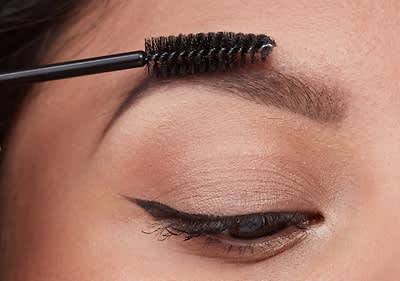 djevojka četkicom češlja obrve