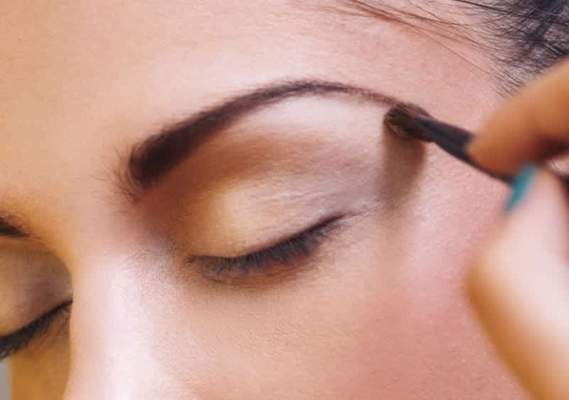 U krupnom kadru kapak i obrva djevojke koja nanosi sjenilo za oči